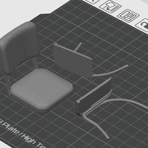 Pu&ograve; includere: Un modello di sedia grigia stampato in 3D, smontato nelle sue componenti. La sedia presenta un sedile, uno schienale e due set di gambe. Le parti sono disposte su una superficie a griglia nera.
