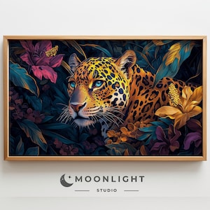 Könnte beinhalten: Ein gerahmter Kunstdruck mit einem Jaguar mit blauen Augen, eingebettet in üppiges, farbenfrohes Laub. Das Fell des Jaguars ist eine Mischung aus gelben und schwarzen Flecken. Das Kunstwerk ist in einem hellbraunen Holzrahmen gerahmt. Der Druck stammt von Moonlight Studio.