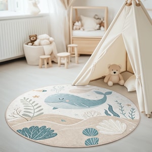 Blue and beige marine motif rug in circle shape, decorated with gentle waves, plants, and a happy whale for kids' floor spaces.