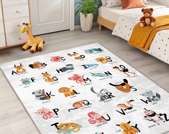 May include: A white rectangular children's rug featuring the alphabet and animal illustrations. Each letter is paired with a corresponding animal, such as "A" for antelope and "B" for beaver. The rug is designed for a child's bedroom.