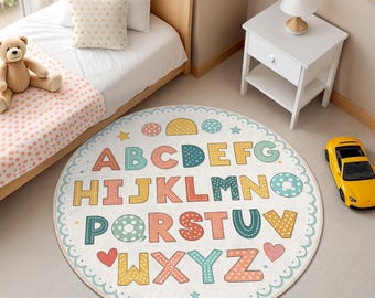 May include: A round alphabet rug with a white background and colorful letters. The letters are decorated with polka dots and have a stitched outline. The rug has a scalloped edge and is surrounded by a light blue border.