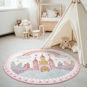 May include: A pink and white round rug with a cartoon illustration of a pink castle with yellow accents and a rainbow arch above it. The rug has a white background with pink hearts around the border.