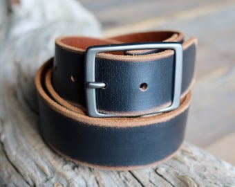 May include: A black leather belt with a brown edge and a silver buckle.