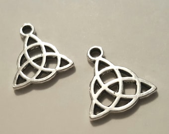 May include: Two silver-toned metal charms in the shape of a Celtic knot, each with a loop at the top for attaching to jewelry or other crafts.