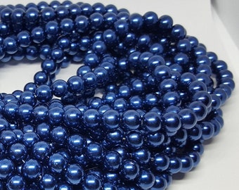 May include: A strand of dark blue pearl-like beads. The beads are round and have a metallic sheen.