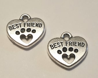 May include: Two silver heart-shaped charms with the text "BEST FRIEND" and a paw print design.