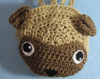 May include: A crocheted pug dog purse with brown and tan yarn. The purse has a brown nose, black eyes, and white accents around the eyes.