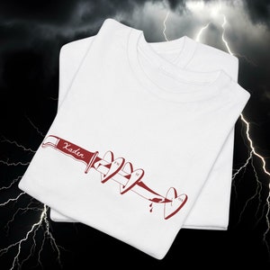 May include: Two white t-shirts are stacked, each with a red graphic of a knife piercing hearts. The knife handle reads "Xader". The hearts display the initials "FW", "IF", and "OS".