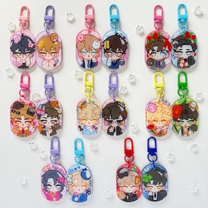 May include: Collection of colorful acrylic keychains featuring anime-style illustrations of various characters. Each keychain has a unique design with different outfits and accessories. The keychains are attached to metal clasps in various colors.
