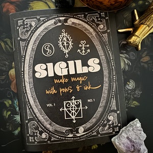 Może przedstawiać: Czarno-biała książka z tytułem "SIGILS make magic with pens & ink" na okładce. Książka jest ozdobiona ozdobną ramką i kilkoma sigilami. Książka jest oznaczona jako "Vol. 1 No. 1".