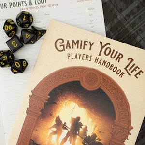 Puede incluir: Una escena de juego de mesa con un manual titulado "Gamify Your Life Players Handbook" con una ilustración de fantasía. Dados negros y amarillos están esparcidos alrededor del libro y una hoja de juego. La escena se desarrolla sobre una superficie blanca.