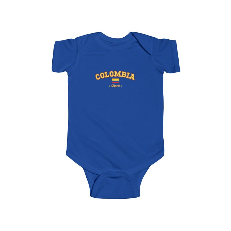 May include: A royal blue baby onesie with a yellow and orange graphic that says "COLOMBIA" with a small yellow and red flag underneath and the word "Shapes" in a smaller font.