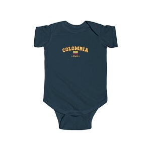 May include: A navy blue baby grow with the word "COLOMBIA" in yellow text with a small Colombian flag and the word "Bogota" in red text.