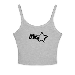 May include: A light gray tank top with thin straps. The front features a black graphic of an eye and two stars. The design has a hand-drawn, grunge aesthetic. The top is made of a soft, likely cotton material.