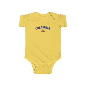 May include: Yellow baby grow with a blue and red Colombian flag and the text "COLOMBIA - Bogota -" printed on the front.