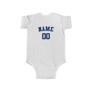 May include: White baby bodysuit with a navy blue 'NAME 00' printed on the back.
