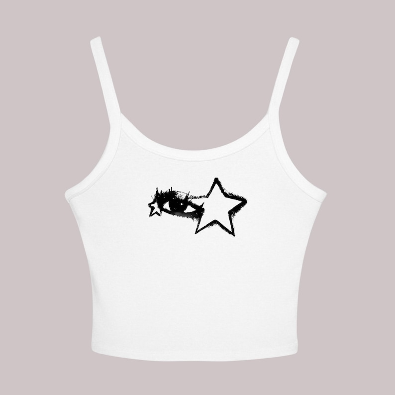 May include: White tank top with thin straps. The top features a black graphic design of an eye and a star. The eye and star design has a distressed, spray-painted aesthetic. The top is made of a soft, lightweight material.