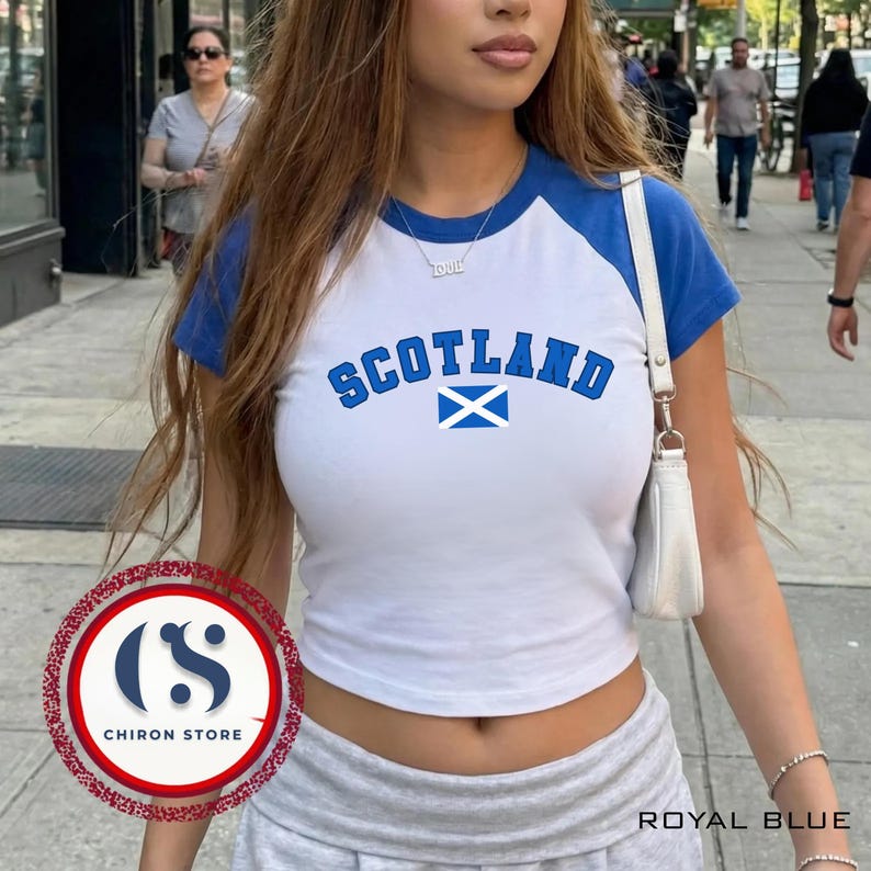 以下が含まれることがあります： 「SCOTLAND」の文字とスコットランドの国旗グラフィックが入った、白とロイヤルブルーのクロップド丈トップス。 ロイヤルブルーの袖とネックラインを備えたベースボールTシャツスタイル。 下部には「ROYAL BLUE」の文字。