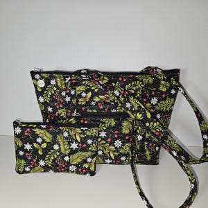 Bolso de mano de tela acolchada con hermosos copos de nieve blancos y vegetación invernal con bayas sobre fondo negro