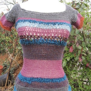 May include: A striped crochet top with short sleeves. The top is made with a variety of colors, including pink, blue, gray, and brown.