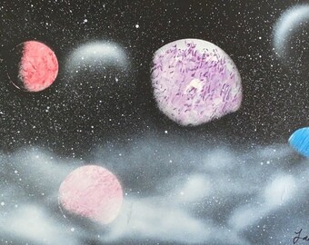 Handmade spray painted image of colorful planets in the dark clouds, ready for clean wall decoration.