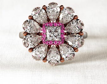 May include: A rose gold ring with a large square-shaped diamond surrounded by smaller pear-shaped diamonds and pink sapphires.