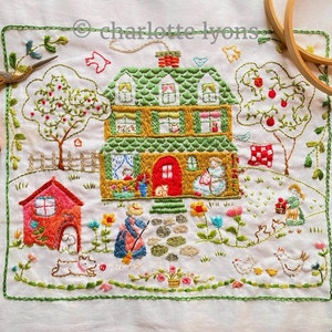 May include: Embroidered cottage scene with a green roof, red door, and a garden. The artwork features a house, trees with red apples, flowers, and figures. The border is green, and the text "charlotte lyons" is visible.