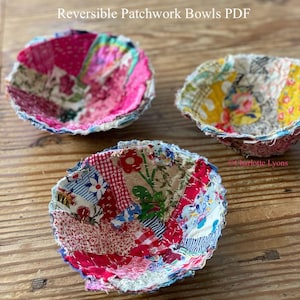 Może przedstawiać: Trzy ręcznie robione miski patchworkowe w różnych kolorach i wzorach leżą na drewnianej powierzchni. Miski wykonane są ze skrawków materiału i mają dwustronny design. Widoczny jest tekst "Reversible Patchwork Bowls PDF".