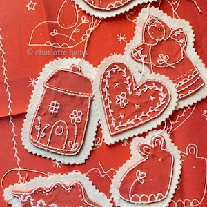 May include: Six handmade felt ornaments with white embroidery. The ornaments are shaped like a bird, angel, house, heart, bunny, and a tree. The ornaments are on a red background with a white star pattern.