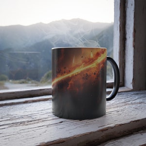 May include: A black coffee mug with a colorful galaxy design. The mug is filled with a hot beverage and steam is rising from the top.