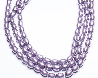 May include: A strand of lavender-colored oval-shaped beads. The beads are strung on a clear thread and are arranged in a layered pattern.