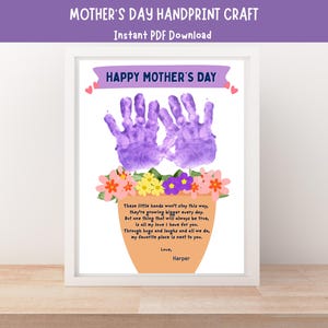 May include: A framed Mother's Day handprint craft. The artwork features two purple handprints above a flower pot with colorful flowers. The text "HAPPY MOTHER'S DAY" is at the top, and a poem is below the handprints. The name "Harper" is at the bottom.