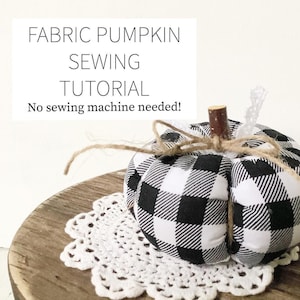 May include: A black and white checkered fabric pumpkin with a twine bow and a wooden stem. The pumpkin is sitting on a white doily on a wooden surface. The text "FABRIC PUMPKIN SEWING TUTORIAL No sewing machine needed!" is written above the pumpkin.