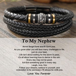 Peut inclure: Bracelet en cuir tressé noir avec des détails argentés et dorés. Le bracelet est doté d'un fermoir magnétique. Le texte "To My Nephew" et un message affectueux sont présents. Un cadeau attentionné.