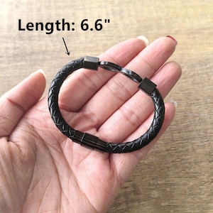 May include: Black leather bracelet with a silver infinity symbol clasp. The bracelet is 6.6 inches long.
