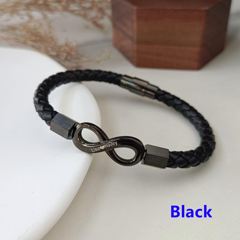 May include: Black leather bracelet with an infinity symbol charm engraved with the names "Lisa" and "Henry".