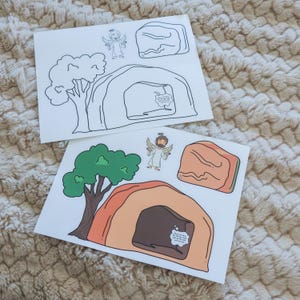 May include: Two sheets of paper with illustrations of an angel, a tree, a tomb, and a rock. One sheet is colored, featuring green, brown, and orange hues. The other sheet is a black and white outline of the same images.