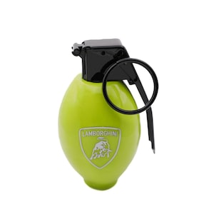 May include: A lime green, grenade-shaped object with a black top and pull ring. The object has a silver Lamborghini logo on the front. The design is sleek and modern, with a focus on the brand's iconic imagery.