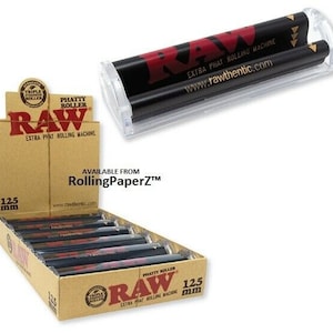 May include: A box of RAW Extra Phat Rolling Machine 125mm rolling papers. The box is brown with gold lettering and a black and red RAW logo. The rolling machine is clear plastic with a black and red RAW logo. The rolling machine is designed to roll large diameter joints.