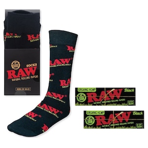 May include: A pair of black socks with a red RAW logo pattern. The socks are packaged in a black box with the RAW logo and the text "Socks RAW Natural Rolling Papers Size: US 10-13". Two packs of RAW rolling papers are also shown, one with the text "Organic Hemp RAW Natural Unrefined Rolling Papers Black 1 1/4 Size" and the other with the text "Organic Hemp RAW Natural Unrefined Rolling Papers Black 1 1/4 Size".