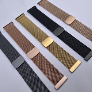 May include: A selection of watch straps in metallic shades: black, gold, rose gold, and silver. The straps are crafted from a fine mesh material and have coordinating clasps. The straps are presented on a white background.