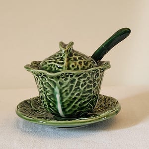 May include: A set of three ceramic mugs with a speckled, matte finish. The mugs are in shades of cream, light gray, and dark gray. Each mug has a simple, minimalist design, perfect for coffee or tea.