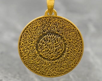 Può includere: Una collana con un ciondolo rotondo in oro decorato con intricata calligrafia araba. Il ciondolo è circondato da un cerchio di motivi più piccoli e ripetitivi.