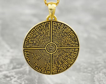 Può includere: Collana con ciondolo rotondo in oro, decorata con un designo intricato di forme geometriche e linee. Il ciondolo è in metallo e ha una finitura lucida.