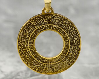Può includere: Una collana con un ciondolo rotondo in oro decorato con intricata calligrafia araba. Il ciondolo ha un grande cerchio aperto al centro.