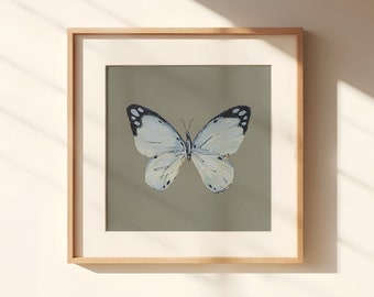 May include: A framed print of a white butterfly with black markings on a sage green background.