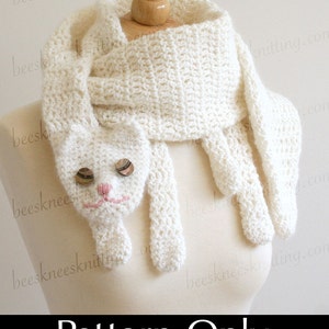 May include: A white crocheted scarf with a cat face design. The scarf is displayed on a mannequin. The text "Pattern Only (Scarf Not Included)" is printed below the scarf.