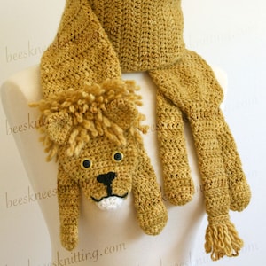 May include: Crochet pattern for a lion scarf. The pattern is for a scarf with a lion's head and paws. The scarf is a mustard yellow color. The pattern is for sale, but the scarf is not included.