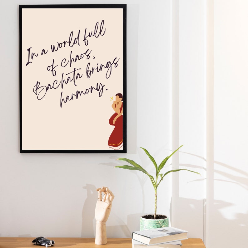 Puede incluir: Una impresi&oacute;n enmarcada beige con fondo negro y texto blanco que dice "En un mundo lleno de caos, la bachata trae armon&iacute;a." Una ilustraci&oacute;n estilizada de una pareja bailando bachata se encuentra en la esquina inferior derecha de la impresi&oacute;n.