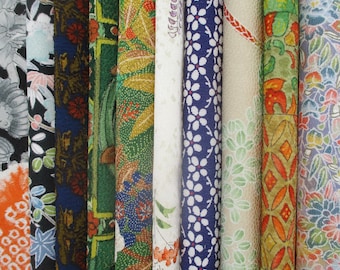 Puede incluir: Una colección de diez tiras de tela verticales con diversos patrones, incluyendo motivos florales, formas geométricas y diseños japoneses tradicionales en una vibrante paleta de tonos rojos, verdes, azules, blancos, naranjas y morados.